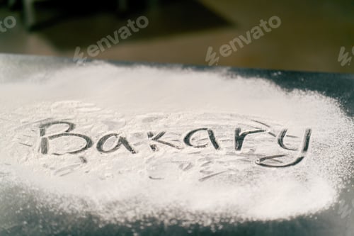 Preview: Creative inscription in large letters with flour on the kitchen surface on the table Bakery