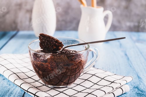 Preview: Chocolate cupcake with powdered sugar in a mug on the table