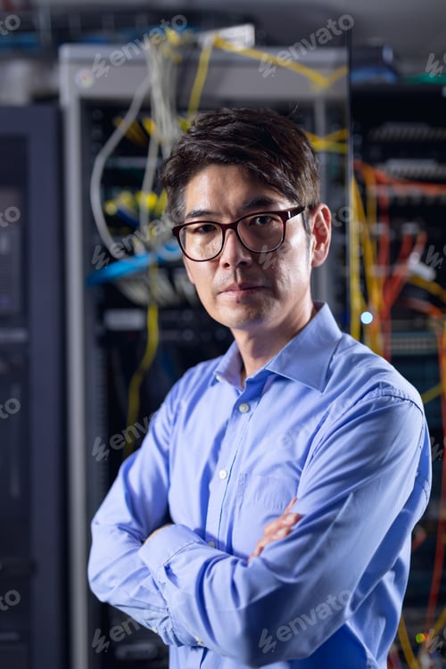 Preview: Portrait of asian male engineer with arms crossed in computer server room
