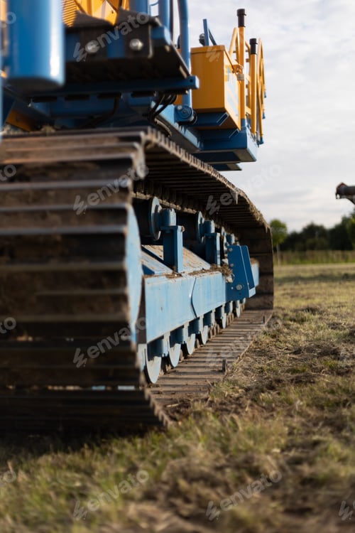 Preview: Vertical shot of large industrial machinery on a meadow