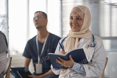 Preview: Smiling Female Health Practitioner with Notebook at Conference