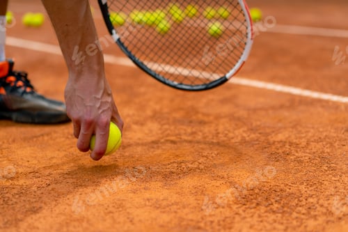 Preview: young coach or player holding tennis racket and ball while playing on court close-up