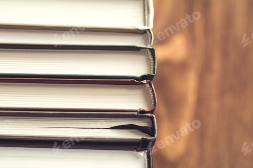 Preview: Stack of books over wooden table. Toned.