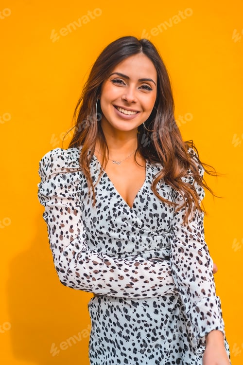 Preview: A pretty brunette smiling with a yellow background behind