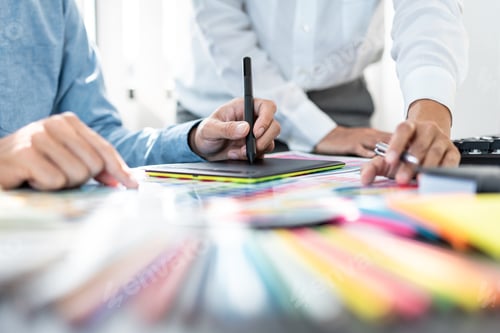 Preview: Two creative graphic designer team working on color selection and drawing on graphic tablet