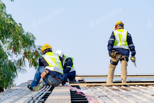 Preview: workers installing solar panels, for efficient energy on rooftop