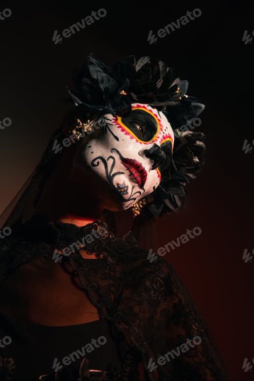 Preview: Woman in wreath with black flowers and catrina makeup looking away on burgundy background