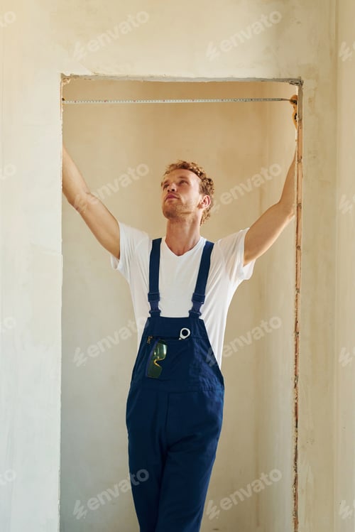 Preview: Modern technologies. Young man working in uniform at construction at daytime