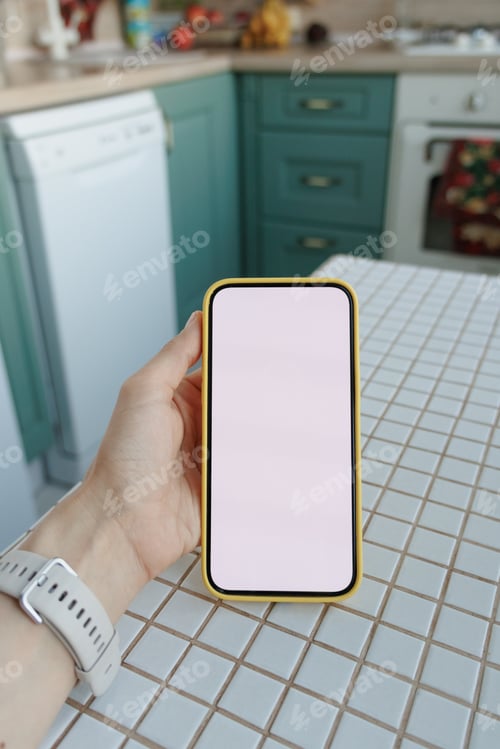 Preview: Close-up of human hand holding black white-screen mobile phone in interior background. mockup