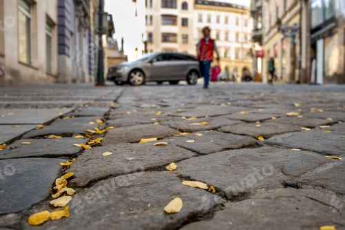 Preview: Stone pavement with blurred car parked on city street side in residential discrict. Urban