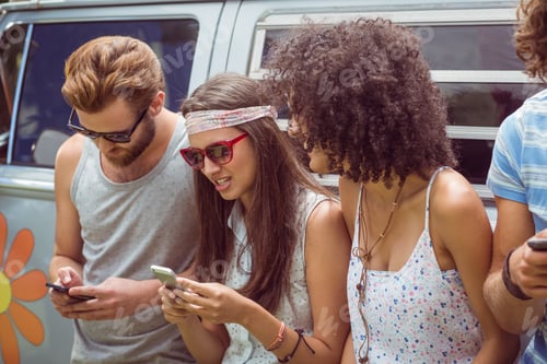 Preview: Hipster friends using their phones on a summers day
