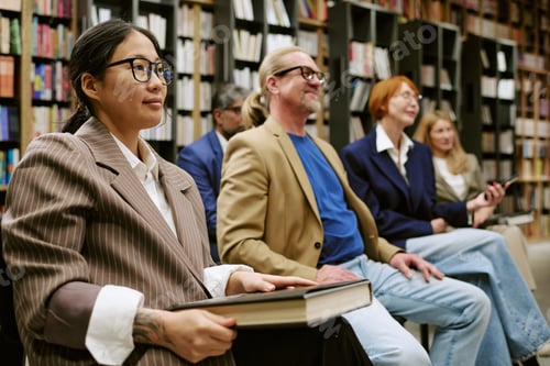Preview: Diverse Group of Adults Attending Presentation with Books in Library Setting