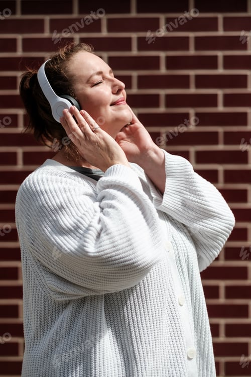 Preview: Woman enjoying music with headphones and closing her eyes