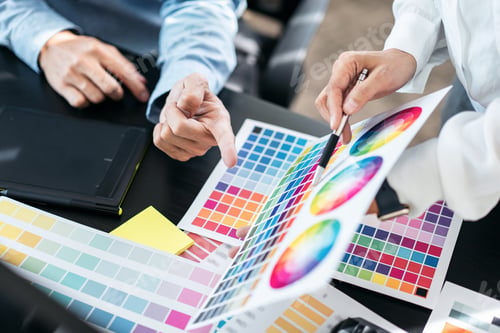 Preview: Two creative graphic designer team working on color selection and drawing on graphic tablet