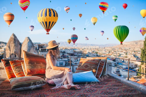 Preview: Happy young woman during sunrise watching hot air balloons in Cappadocia, Turkey