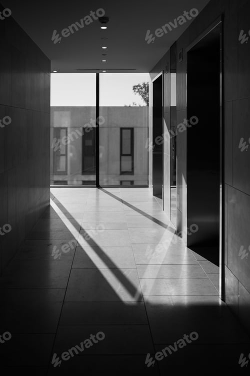 Preview: Vertical grayscale shot of the entrance of a modern building