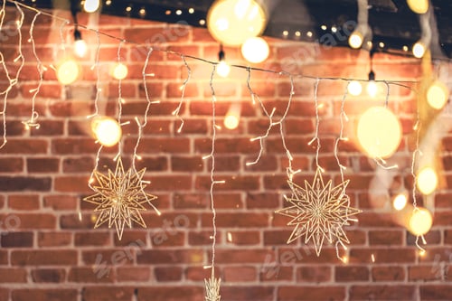 Preview: Lights garlands hanging from brick wall at evening, Christmas house decoration.