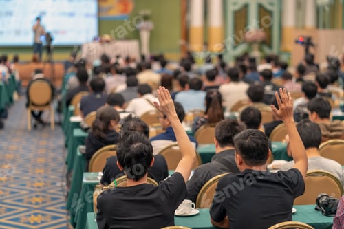 Preview: Rear view of Audience showing hand to answer the question from Speaker on the stage