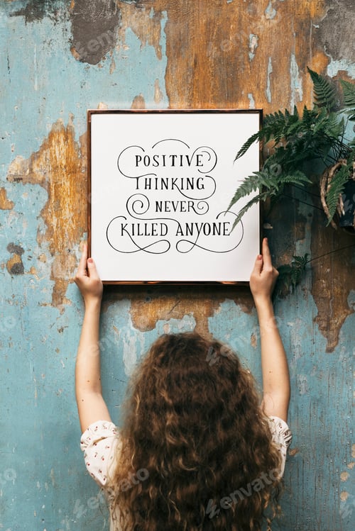 Preview: Woman hanging a frame mockup on a grunge blue wall