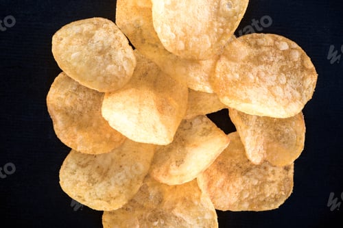 Preview: close-up view of crispy unhealthy potato chips isolated on black