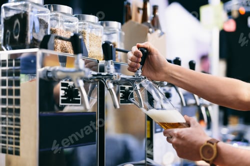Preview: Bartender pouring craft beer from a tap at beerfest