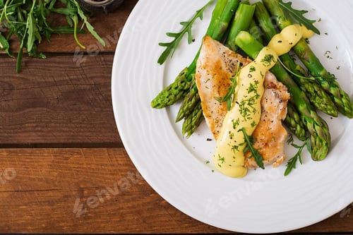 Preview: Baked chicken garnished with asparagus and herbs. Top view