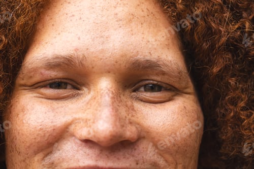 Preview: Portrait close up of happy biracial man with red curly hair and freckles smiling