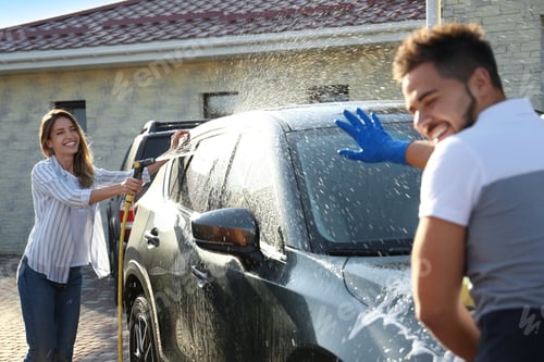 Preview: Happy couple washing car and having fun at backyard on sunny day