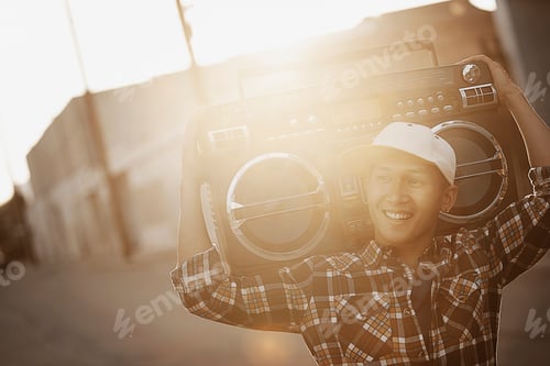 Preview: A young man with a boombox on his shoulder on the street of a city.