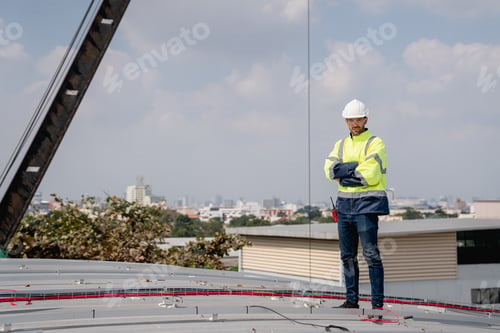 Preview: Service engineer installing solar cell on the roof of factory. Clean and Renewable energy concept.