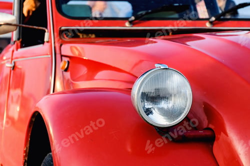 Preview: Round head light on vintage red car.