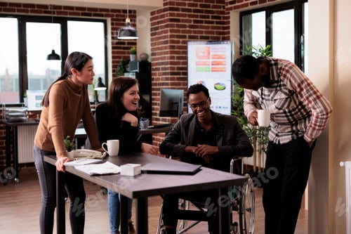 Preview: Entrepreneur sitting in wheelchair and talking to business partners