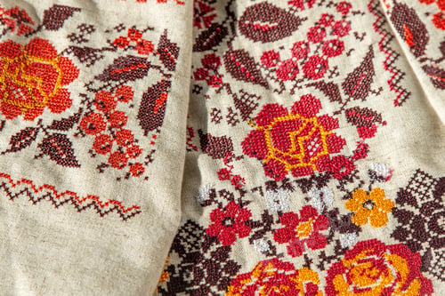 Preview: Ukrainian clothes embroidered shirt. Red orange and black threads background. Vyshyvanka is a symbol