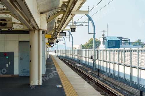 Preview: Modern railway platform in urban station with yellow tactile paving and overhead signal
