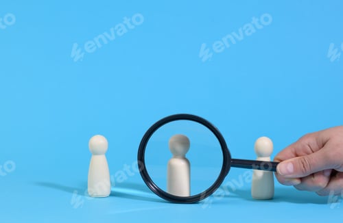 Preview: Wooden figures of men stand on a blue background and a black magnifying glass.