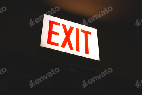 Preview: Illuminated Red Exit Sign Against a Dark Background
