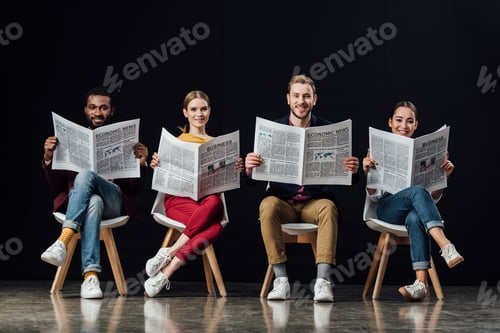 Preview: smiling multiethnic group of casual businesspeople sitting on chairs and reading business newspapers