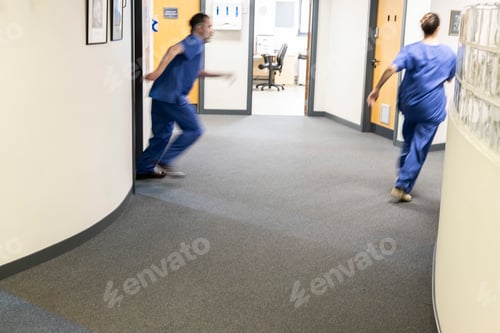 Preview: Healthcare professionals running in a clinic corridor of a medical practice
