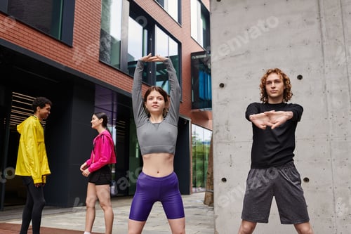 Preview: Dynamic group of young athletes stretching outdoors in an urban setting at daytime