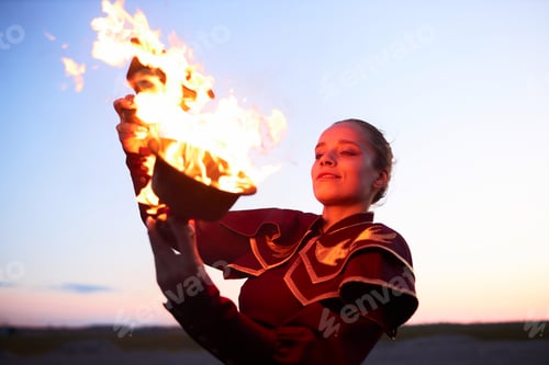 Preview: Smiling Woman Dancing with Fire Bowls And Looking At Flames