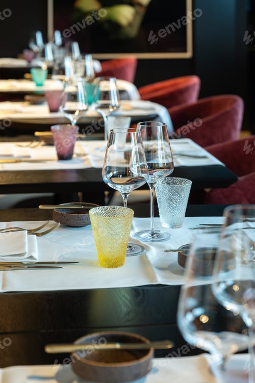 Preview: Closeup of wineglasses amid vibrant restaurant backdrop