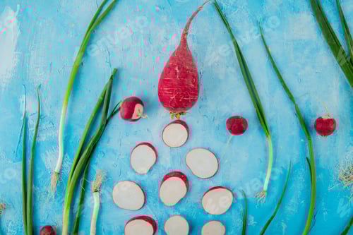 Preview: close-up view of vegetables as whole and sliced radish and scallion on blue background