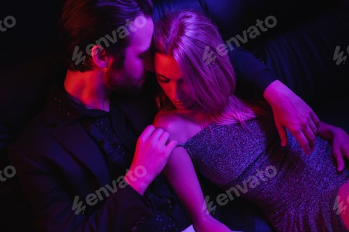 Preview: High angle view of sexy man touching blonde girlfriend on leather couch with lighting isolated on