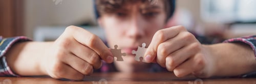 Preview: young person hands solving puzzle at the table f