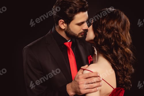 Preview: Elegant man kissing girlfriend while taking off dress isolated on black