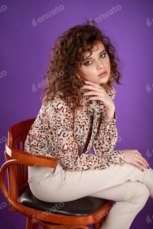 Preview: Vertical photo fo young lady sittin on a chair on purple background