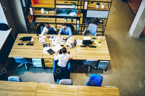 Preview: African American office employee discussing startup with colleagues in office