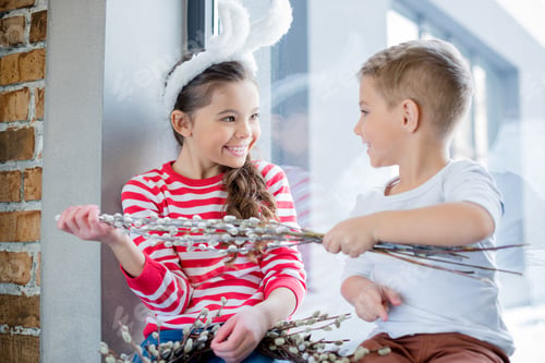 Preview: Cute smiling boy and girl holding catkins and looking at each other