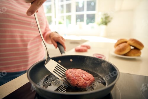 Preview: Close Up Of Woman At Home In Kitchen Frying Beef Patty Or Burger In Pan