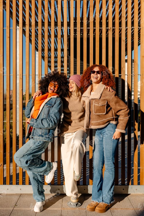 Preview: Three happy women leaning against wooden wall enjoying their time together